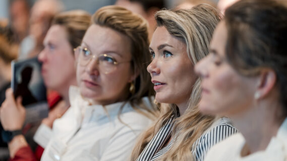 Vrouwen zitten in een zaal